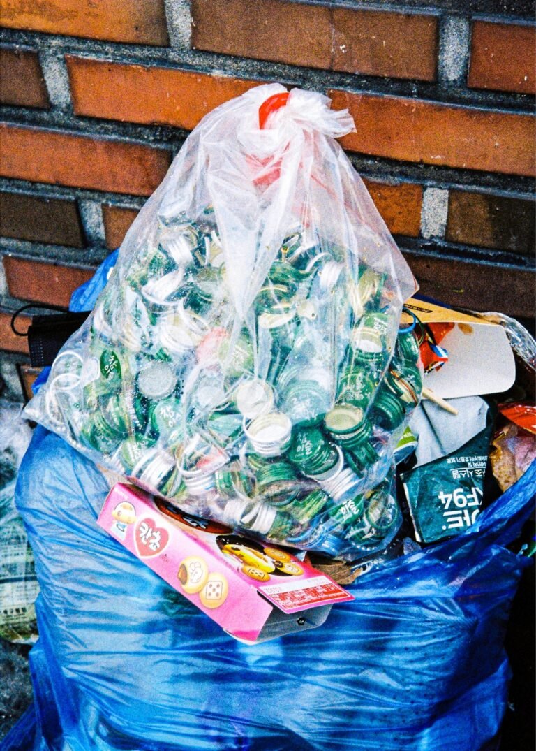 a bag full of garbage sitting next to a brick wall